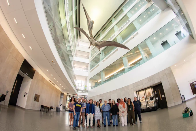 Photo of paleontologists under pterosaur model.