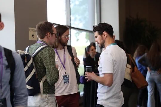 A group of Outlier attendees and speakers socializing. 