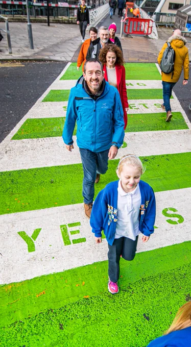 Chris Boardman on a zebra crossing with school pupils and Living Streets staff.