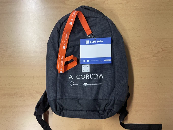 Fotografía de un identificador personal (en blanco) del congreso CEDI sobre una de las mochilas del congreso.