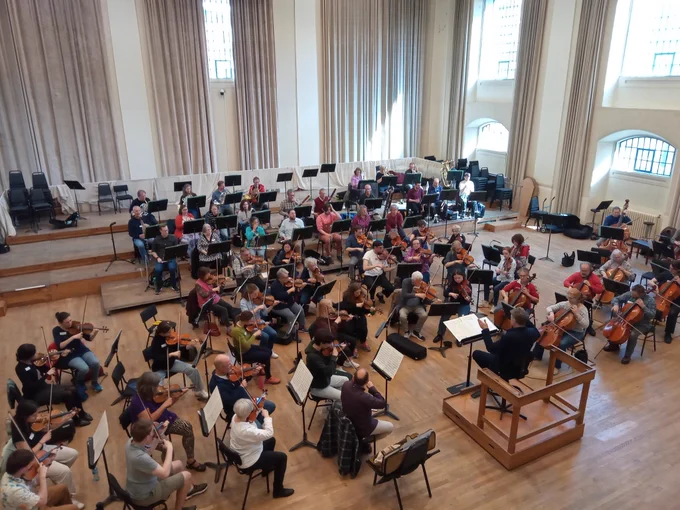A large orchestra (though without percussion for today) in rehearsal.