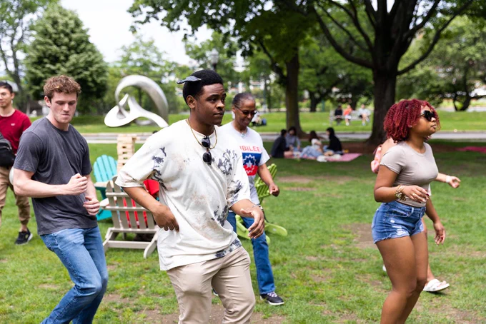 Justin Durik (from left), Caleb Simmons, Detris Adelabu, a clinical professor at Wheelock College of Education & Human Development, and Amiya Jenkins, a BU summer intern, dance the “Cha-Cha Slide,” during Boston University’s 2023 Juneteenth BBQ.