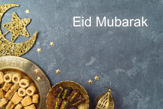 A selection of sweets on a grey background with the text "Eid Mubarak"