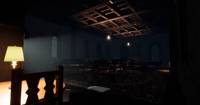 A sparsely lit room with many chairs and tables. Lightbulbs hang from the ceiling.
