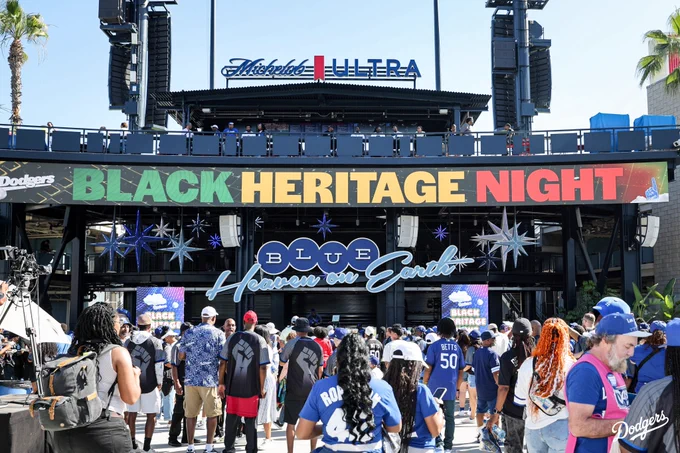 A photo of fans in the Centerfield Plaza with the Black Heritage Night signage on the ribbon board.