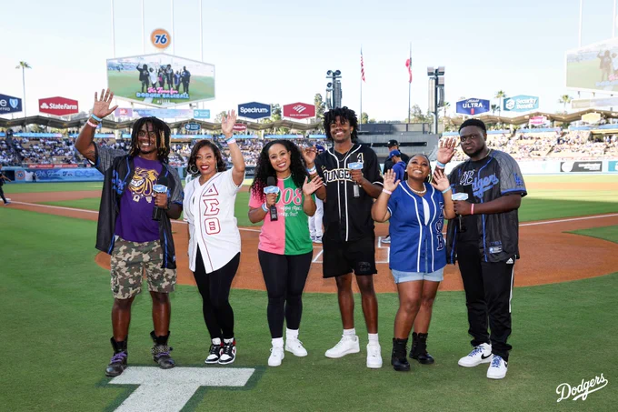 A photo of members from the Divine Nine on the field saying, "It's Time for Dodger Baseball."