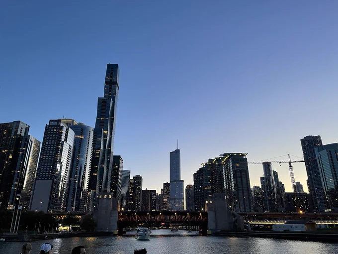 View of Chicago from the lake by night. Lots of skyscrapers in front of the sunset.