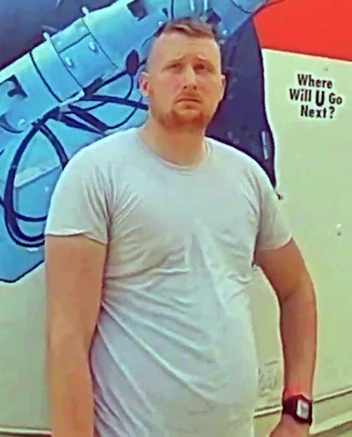 A video still of bodycam footage, edited by the Boston Globe, depicting Keith Mathew Ray of Williamsport PA. He is standing in front of a UHaul truck, with a hand on his hip.