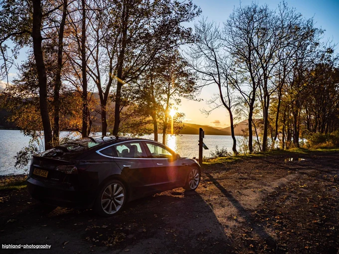 Tesla car in autumnal Highland scenery