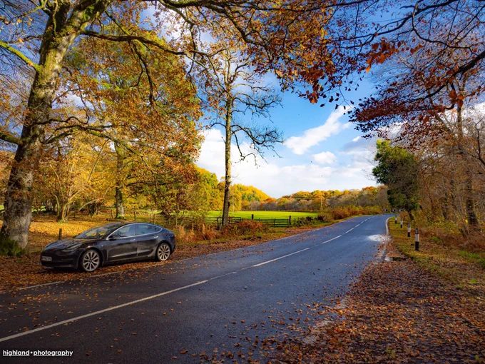 Tesla car in autumnal Highland scenery