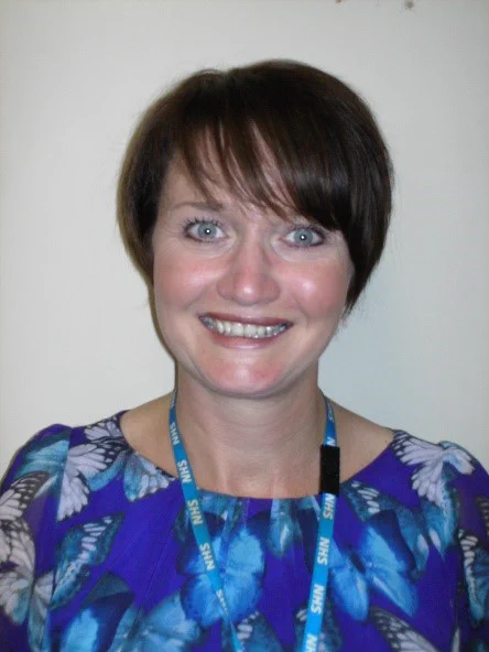 Jo, nurse smiling with lanyard on