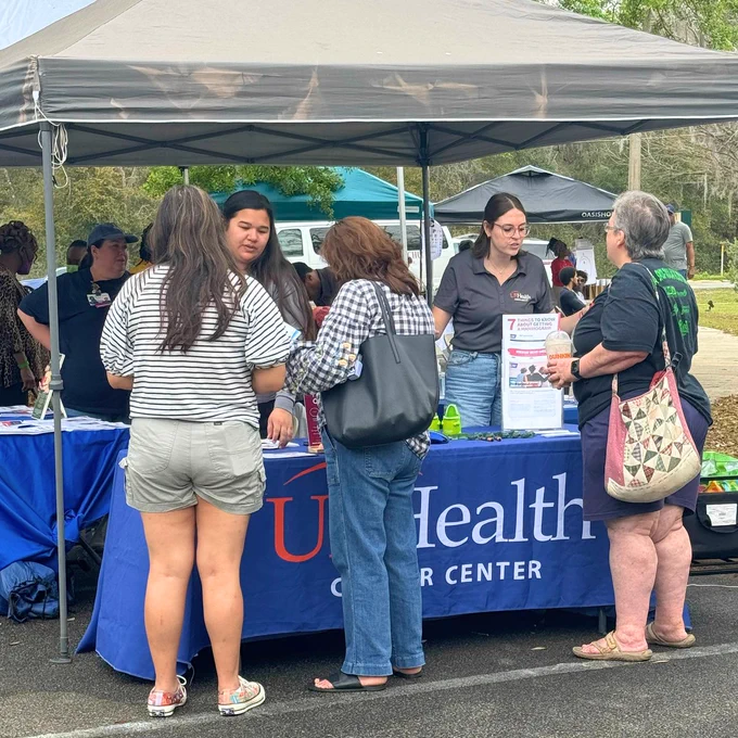 The UF Health Cancer Center team provides information and services at a table at a community event.