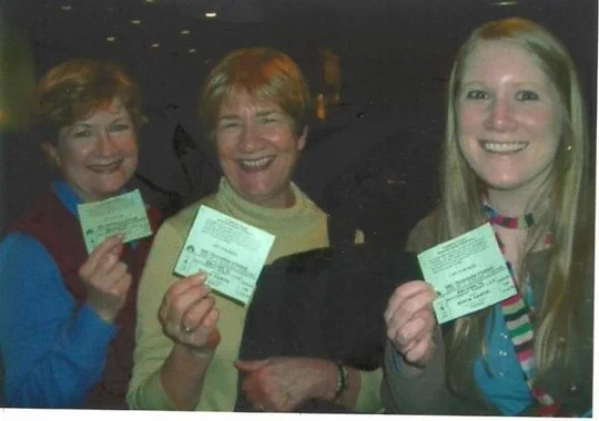 An older, faded digital photo from 2006 featuring three women holding tickets for an SNL dress rehearsal. The two women on the left are older and look like sisters (they are). The woman on the right is younger and has long, blonde hair. 