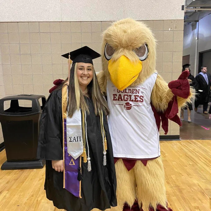 Goldie taking a photo of a student at commencement