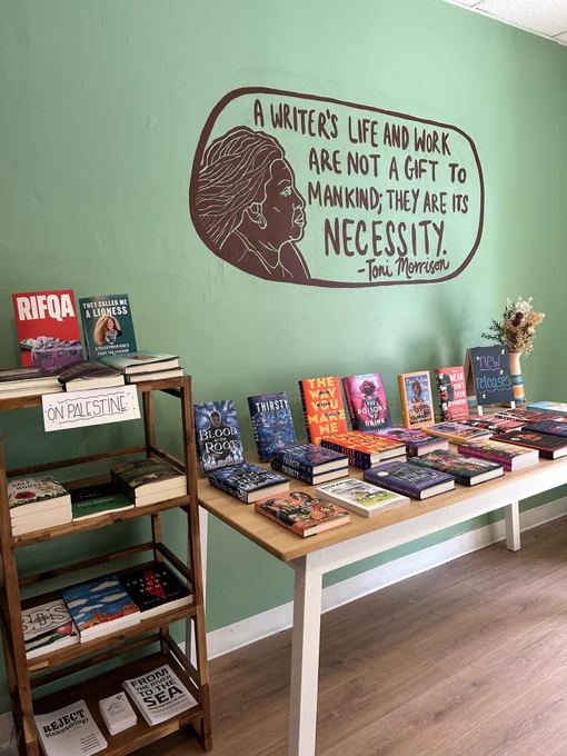 Image of Call & Response Books entryway featuring a Toni Morrison quote mural and table displays.