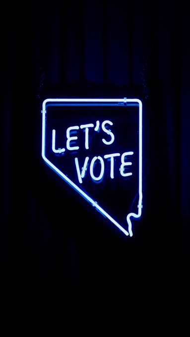 Image with a black background displaying a neon sign that says 'Let's vote'.