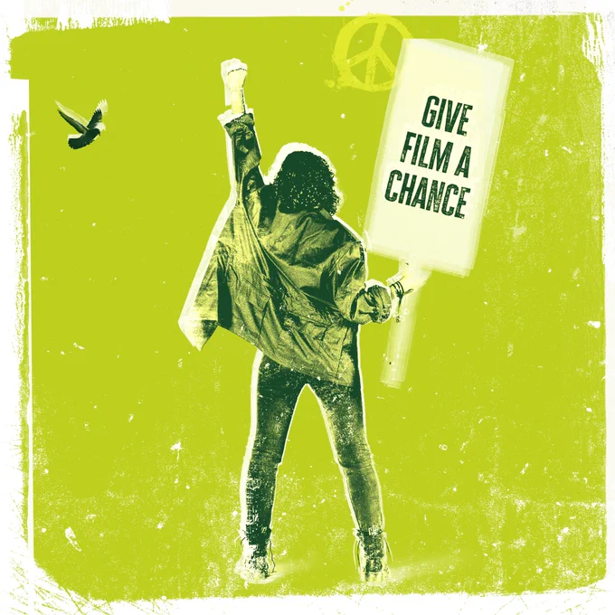 Green background with a person facing away, hand in the air, the other holding a placard saying "Give film a chance"