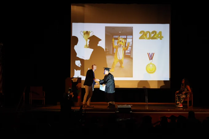 A graduate walks the stage to get an award.