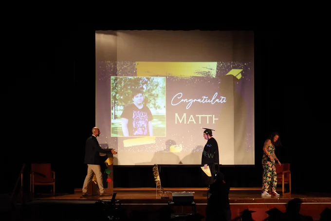 A graduate walks the stage to get their middle school diploma.