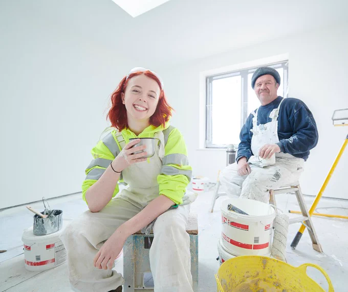 female apprentice painter and painter enjoy a break