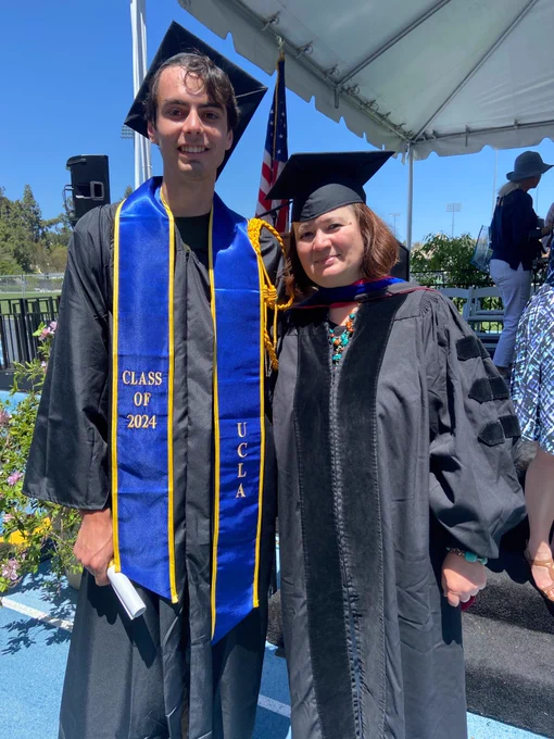 Leo Morag(left, holding the commencement event program paper) standing next to his P.I., Prof. Paula Diaconescu(right). They are seen wearing graduation gowns and caps. 