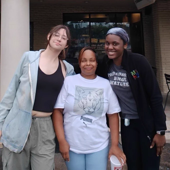 Three SBWU members pose and celebrate in front of their newly unionized Starbucks store!