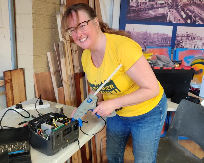 lady in yellow with a glue gun