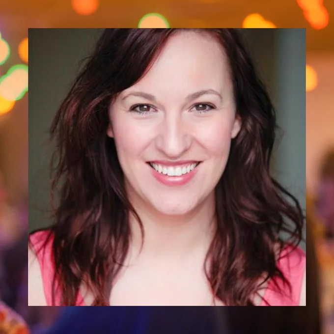 Headshot of Michelle smiling towards the camera, border with orange-filtered, blurry image from Framework Festival 2023.