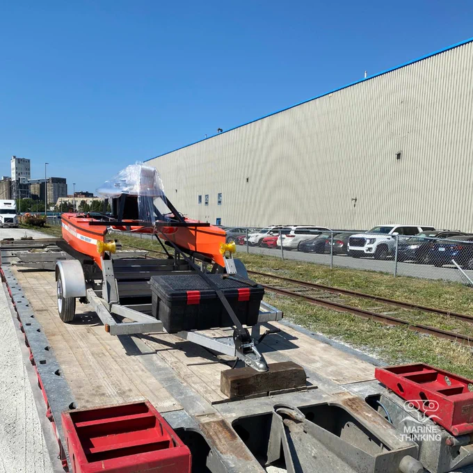 Marine Guardian uncrewed surface vessel (USV) securely mounted to a trailer, resting on a flatbed.  