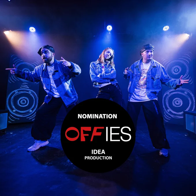 Image is a production photo of three actors posing as a 90’s pop group at camden people’s theatre. There are large piece of furniture made to look like speakers behind the actors. There is an offies badge in the middle of the picture. It’s a large black circle with text on it that reads: Nomination OFFIES idea production.