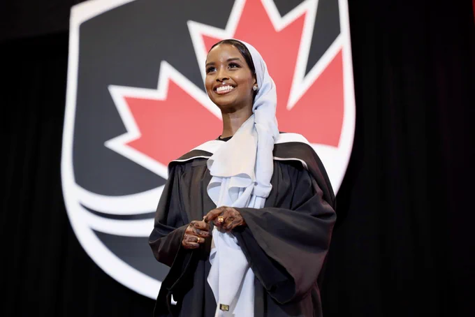 A grad smiling as she crosses the stage.