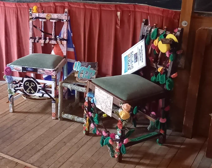 Two decorated chairs representing stories from rural communities in Norfolk.