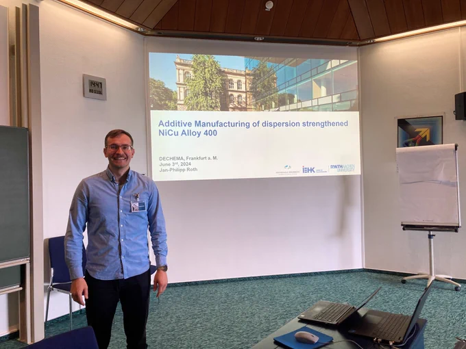 Man in a seminar room in front of a presentation screen