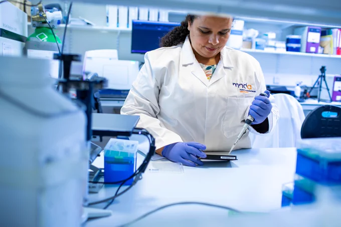 Person in a laboratory wearing an MND Association lab coat 