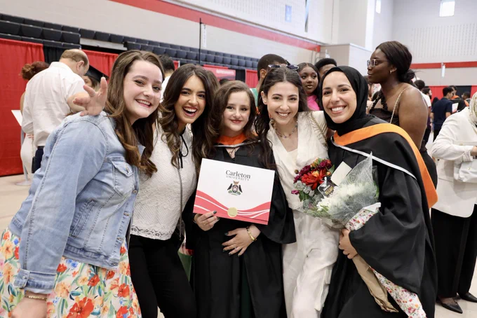A group of grads and friends smile together at convocation reception.