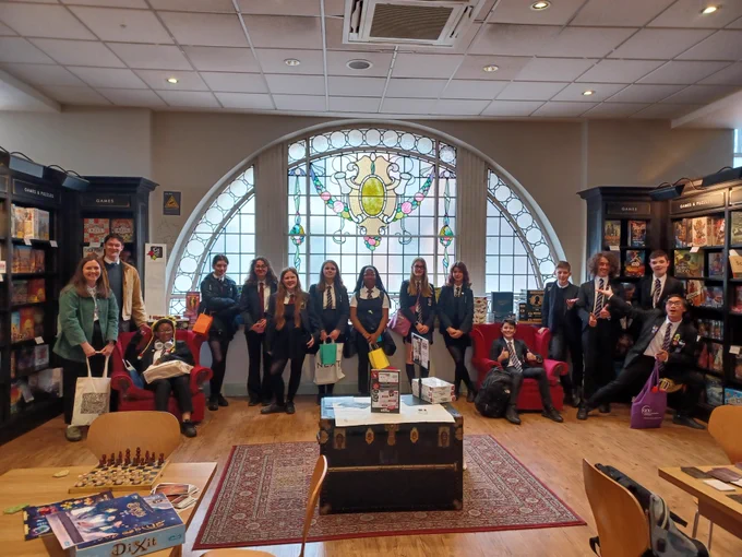 Library assistants in the Waterstones at Sauchiehall Street, smiling for the camera. A couple of them are sitting in red comfy chairs.