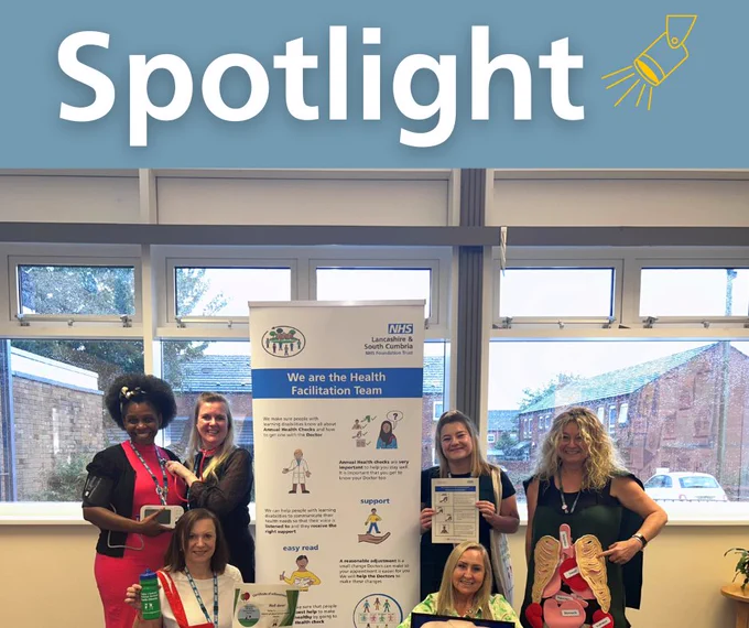 spotlight - colleagues of the health facilitation team smiling next to a pull up banner