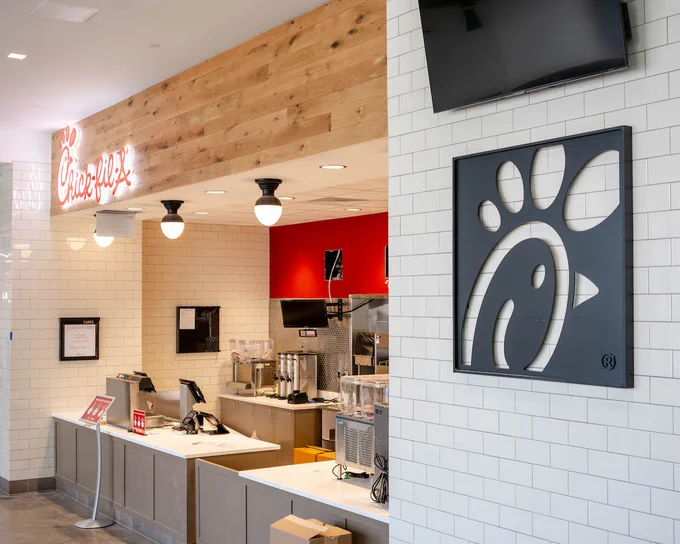 A dining venue with the Chickfila logo and small overhead lighting. 