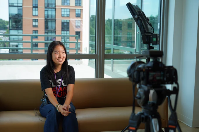 Fellow Kayla seated with a camera facing her and a key light on her left