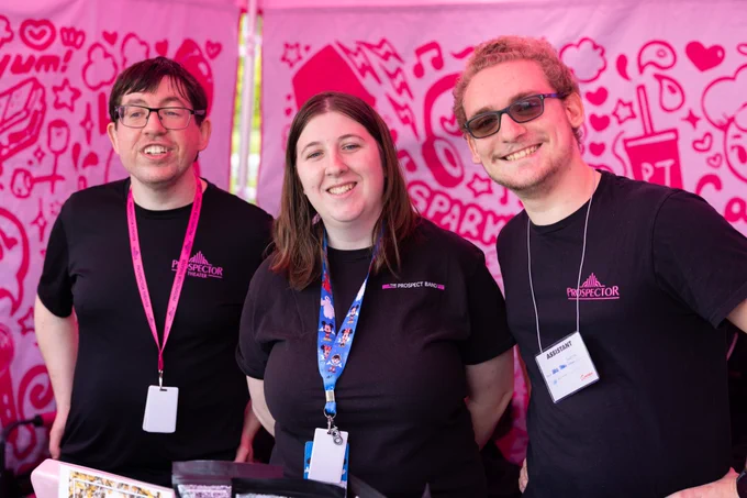 Dillon, Amanda, and Matt smile while working at a popup tent.