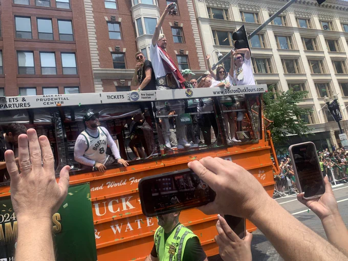 Kristaps Porzingis triumphantly catches a beer while on a duck boat in the Boston Celtics victory parade