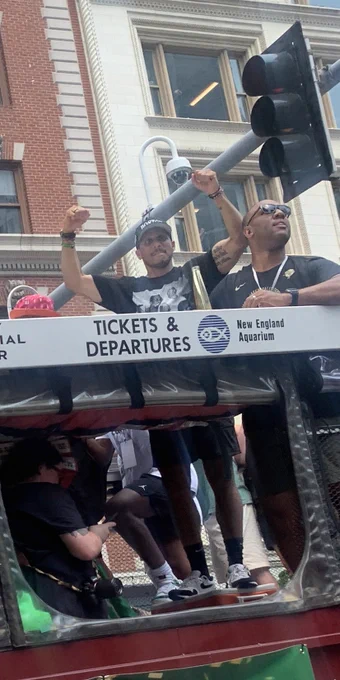 Joe Mazzulla puts his hands up while on a duck boat in the Boston Celtics victory parade