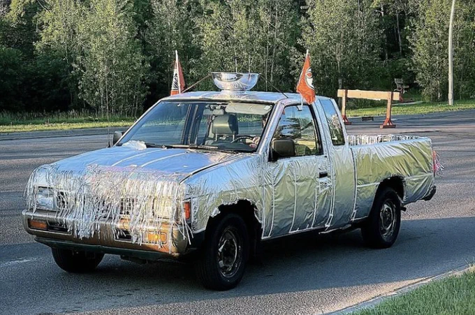 Photo of a car decked out in silver with a silver bowl on top and Edmonton Oilers flags in the windows.