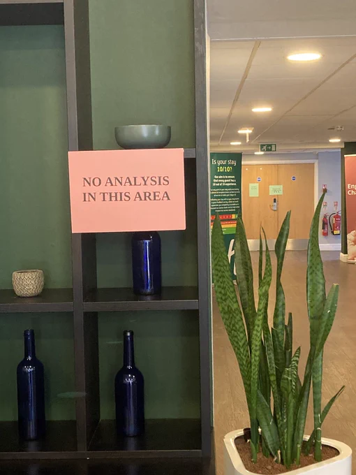 A hotel lobby, with a sign reading “no analysis in this area”.