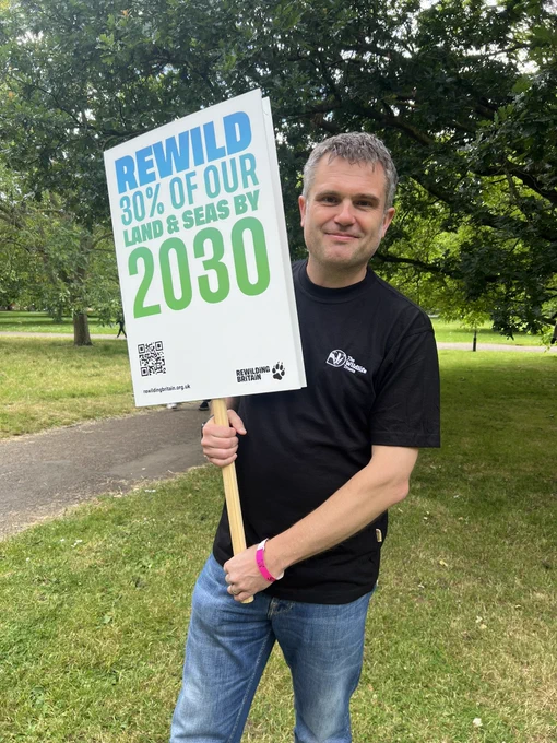 Craig Bennett CEO of The Wildlife Trusts with banner saying ‘Rewild 30% of our land and seas by 2030’