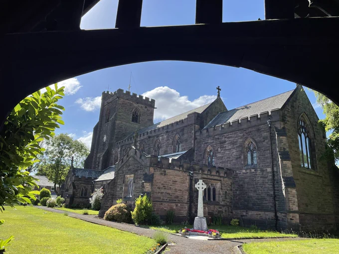 Photo of a church through archway of the entrance to the grounds.