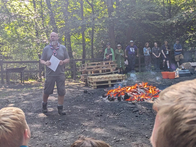 A Scout leader in front of a campfire