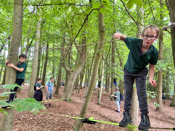 Cub Scouts on a slack line between trees
