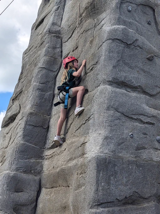A Cub Scout climbing up a climbing wall