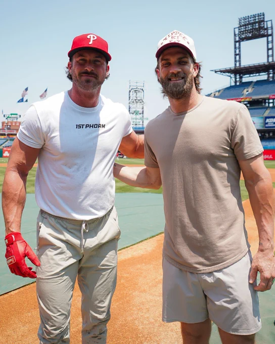Country music singer Riley Green and Bryce Harper standing next to each other on the field at Citizens Bank Park.